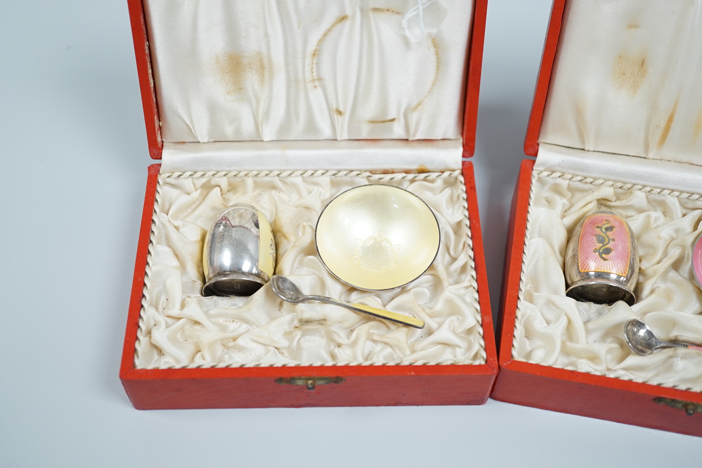 Three cased Danish sterling and enamel three piece condiments sets, by Volmer Bahner & Co, each with different coloured enamel and comprising a salt, pepper and spoon